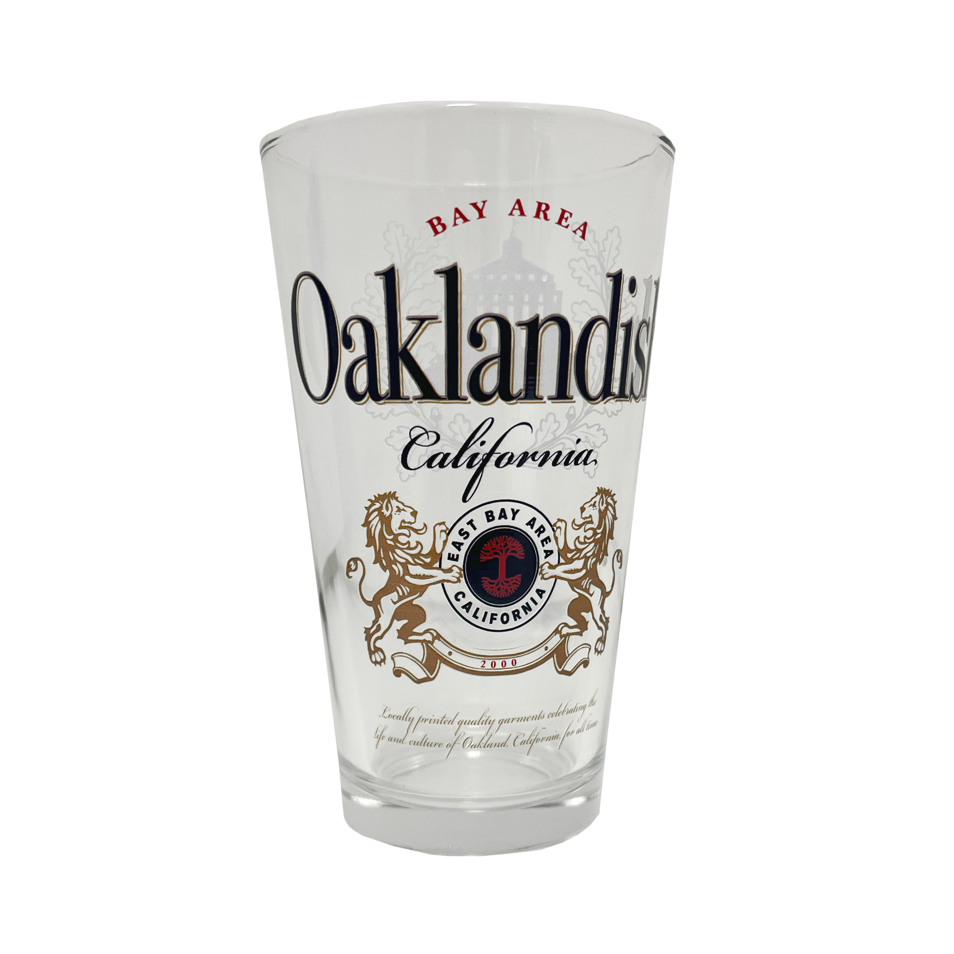 The Lager Pint Glass by Oaklandish is a 16 oz pint glass featuring the text "Bay Area Oaklandish California" in black and red. Below this, intricate graphics depict two lions standing on their hind legs, flanking a red and black emblem that reads "East Bay" and "California." Additional small text appears beneath the emblem, making it perfect for any drinkware collection.